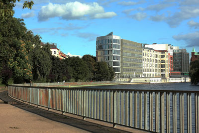 Footpath by buildings against sky