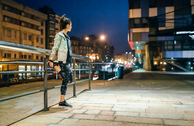 Rear view of man walking on street at night