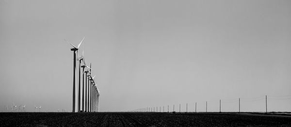 Low angle view of windmill on field against clear sky