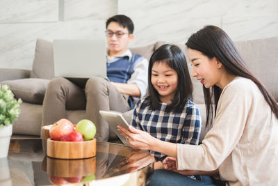 Friends looking away while sitting on table