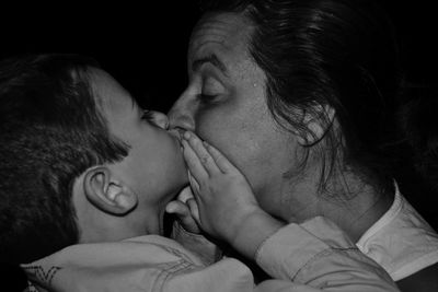 Close-up of mother kissing son at home
