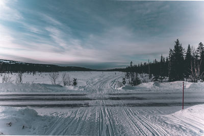 Scenic view of snow covered field against sky