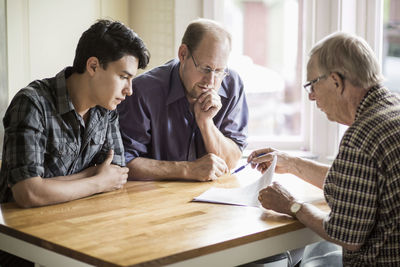 Family discussing over documents at table