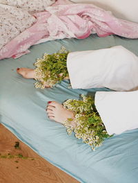 Low section of woman with flowers on mattress