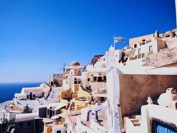 Buildings in city against clear blue sky