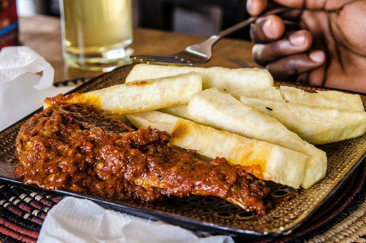 Cropped image of person having fried fish and french fries at restaurant