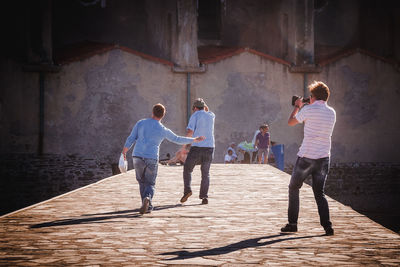 Rear view of people walking on road