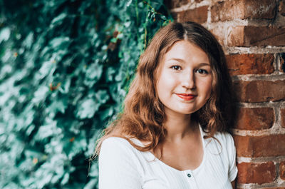 Portrait of smiling girl against wall