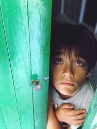 High angle view of cute boy looking up while standing by door at home