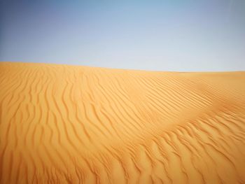 Sand dunes in desert against clear sky