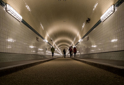 People walking in illuminated tunnel