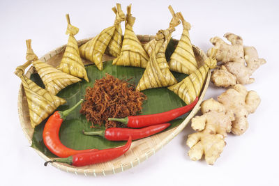 High angle view of meat and leaves on white background