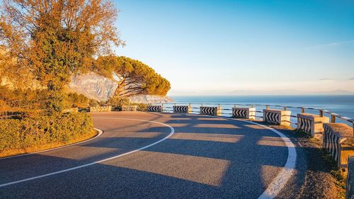 Road by sea against sky during autumn