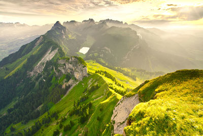 Scenic view of mountain range against cloudy sky