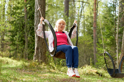 Woman with arms raised in forest