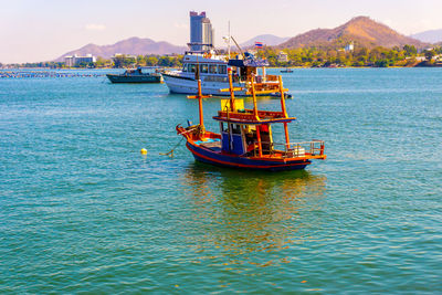 Fishing boat in sea against sky