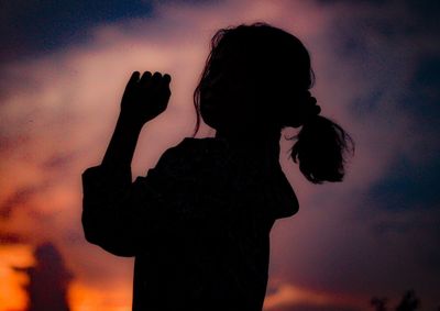 Silhouette woman standing against sky during sunset