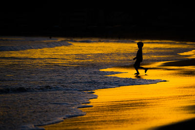 Silhouette man walking on beach