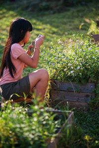 Young woman sitting on plants