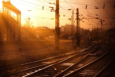 Railroad tracks against sky during sunset