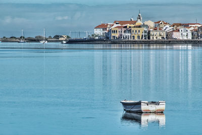 Boats moored in sea against buildings