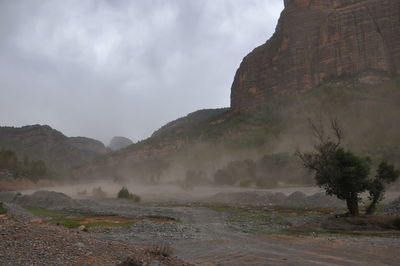 Scenic view of land and mountains against sky