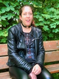 Portrait of smiling young woman sitting on bench