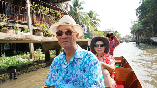 Portrait of couple sitting in boat on river