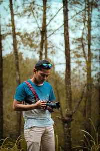 Young man using mobile phone in forest