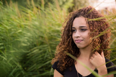 Close-up of young woman with curly hair looking away