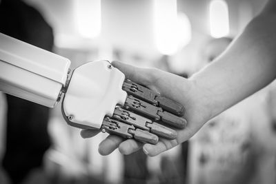 Close-up of man shaking hands with robot
