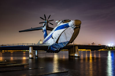 Airplane on bridge against sky at dusk