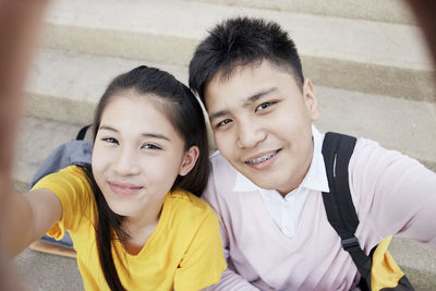 High angle portrait of happy friends on steps in city