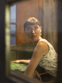 Portrait of woman seen through window