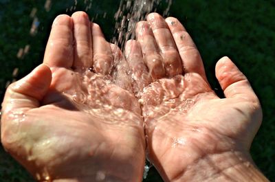 Close-up of hand holding wet water