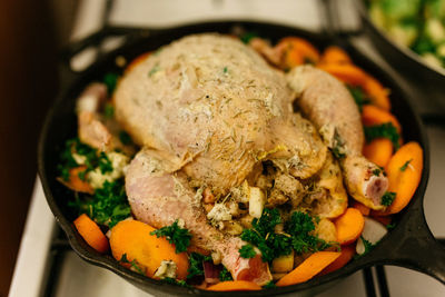 High angle view of chicken with vegetables in frying pan on table