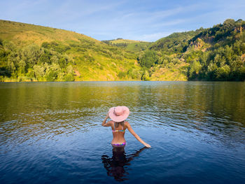 Rear view of woman standing in lake