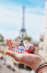 Cropped hand holding macaroons with figurines