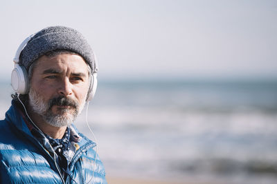 Portrait of young man standing at beach