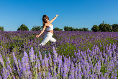 Woman in a lavender field doing the warrior yoga pose