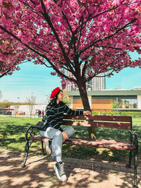 Friends sitting on bench against trees