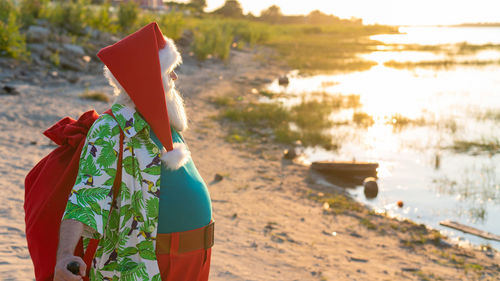 Santa clause standing at beach