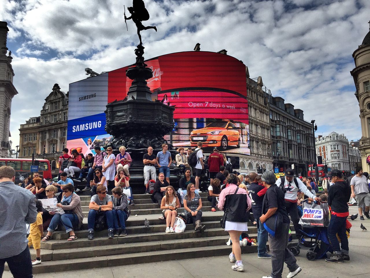 large group of people, architecture, building exterior, built structure, men, person, city, sky, lifestyles, city life, cloud - sky, mixed age range, leisure activity, crowd, travel destinations, cloud, city street, outdoors, tourism, cloudy, day, capital cities, casual clothing