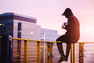 Woman looking at city at sunset