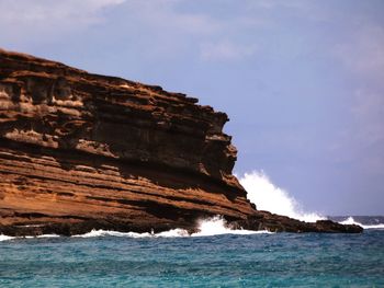 Rock formation on sea against sky