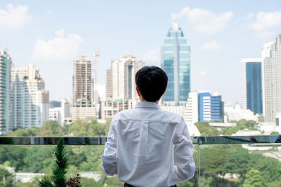 Rear view of man looking at city buildings