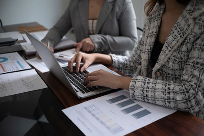 Midsection of business people working on table