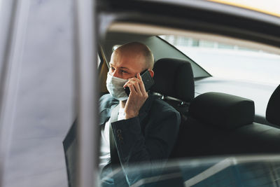 Businessman talking on phone while sitting in car