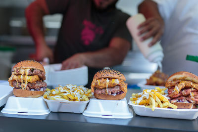 Street food- hamburgers with sausage and chips.