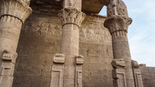 Temple of edfu horus detail hieroglyphics with remaining color at entrance column area